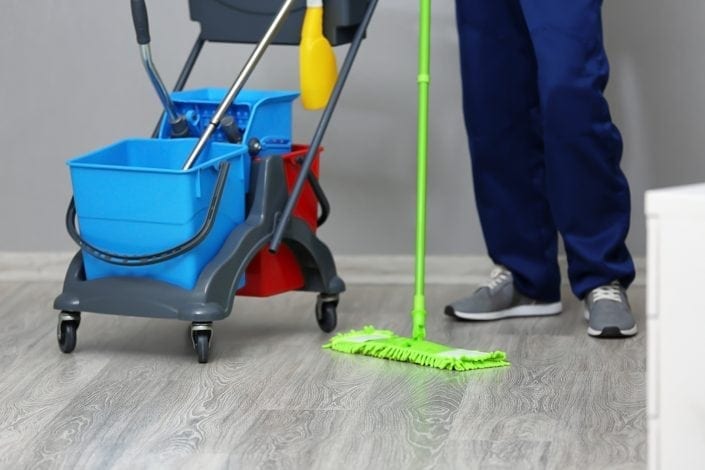 Young man moping floor in office